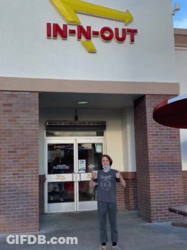 A Person Standing In Front Of An In N Out Restaurant GIF