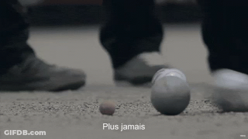 A Person Standing Next To A Ball That Has The Word Plus Jamais On It GIF