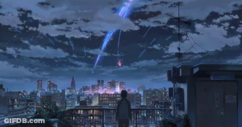 A Person Standing On A Balcony Looking At A City Skyline GIF