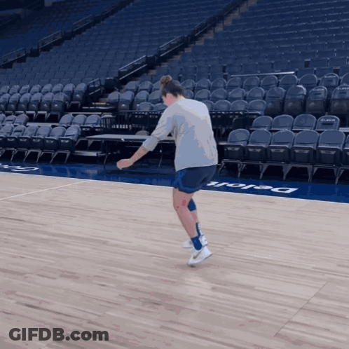 A Person Standing On A Basketball Court That Has The Word Delaware On The Floor GIF