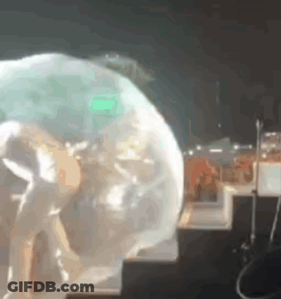 A Person Standing On A Stage With A Green Light Behind Them . GIF