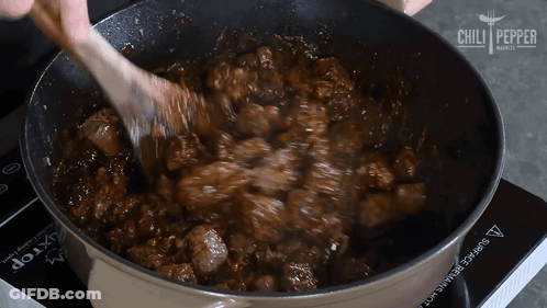 A Person Stirring A Pot Of Food With A Wooden Spoon And The Words Chili Pepper On The Bottom Right GIF