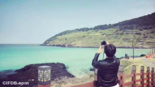 A Person Taking A Picture Of A Body Of Water GIF