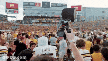A Person Taking A Picture Of A Crowd With A Laneux Jersey On GIF