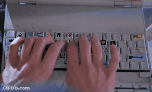 A Person Typing On A Keyboard With Stickers On The Keys GIF