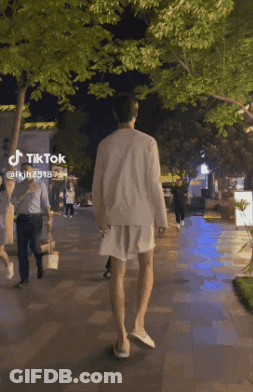 A Person Walking Down A Sidewalk With A Tiktok Logo On The Bottom GIF