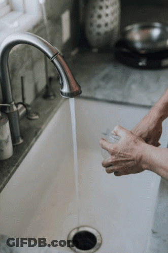 A Person Washing Their Hands In A Sink With Water Running GIF
