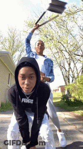 A Person Wearing A Black Fendi Sweatshirt Is Riding Another Person On Their Back GIF