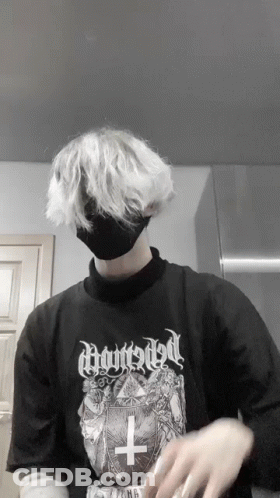 A Person Wearing A Black Shirt With A Cross On It And A Black Mask GIF