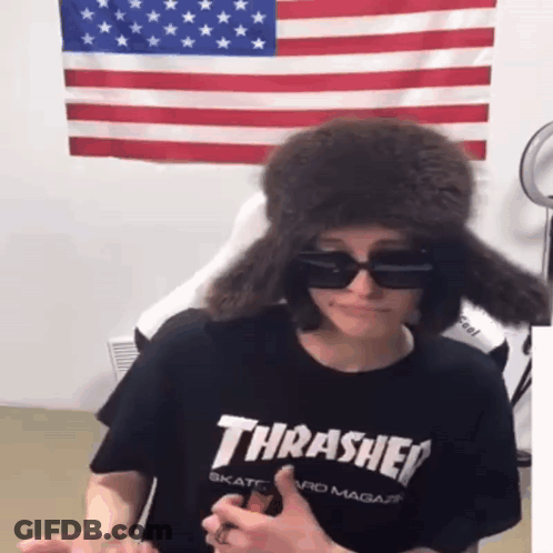 A Person Wearing A Black Thrasher Shirt And A Fur Hat GIF