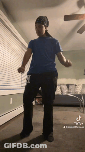 A Person Wearing A Blue Shirt And Black Pants With The Letter L On Them GIF
