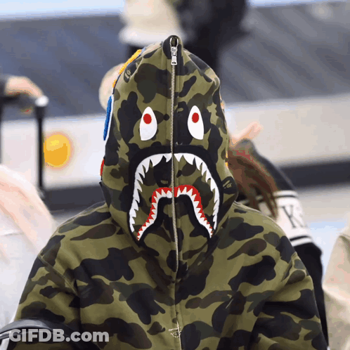 A Person Wearing A Camo Hoodie With A Shark Face On It GIF