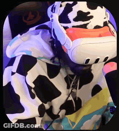 A Person Wearing A Cow Print Hoodie Is Using A Virtual Reality Headset GIF