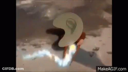 A Person Wearing A Cowboy Hat Is Standing On A Beach With A Flame Coming Out Of It . GIF