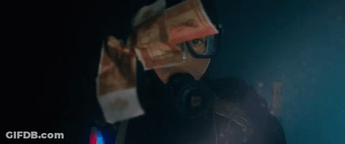 A Person Wearing A Gas Mask And Goggles Is Holding A Bunch Of Money In Front Of Their Face . GIF