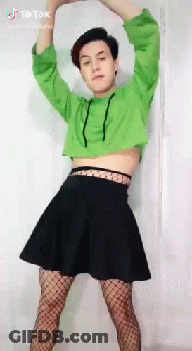A Person Wearing A Green Crop Top And A Black Skirt Is Dancing . GIF