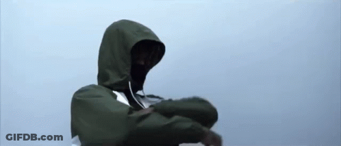 A Person Wearing A Green Jacket With A Hood Is Standing In The Rain . GIF