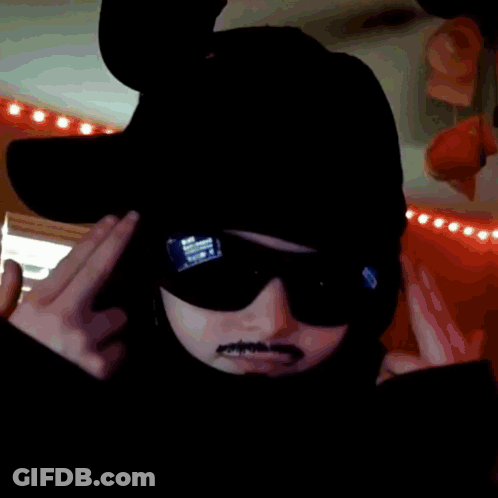 A Person Wearing A Hat And Sunglasses Is Making A Funny Face GIF