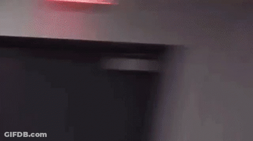 A Person Wearing A Hat Is Standing In Front Of A Wall . GIF