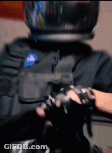A Person Wearing A Helmet And Gloves Is Holding A Gun GIF
