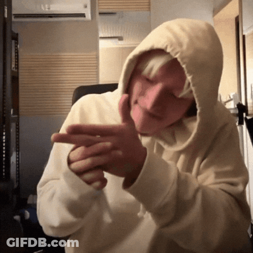 A Person Wearing A Hooded Sweatshirt Is Making A Funny Face GIF