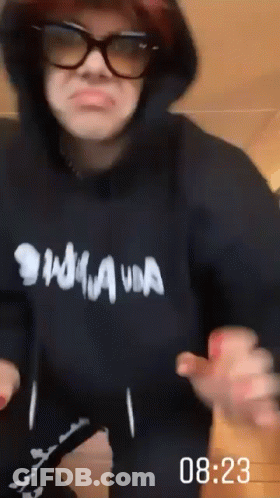 A Person Wearing A Hoodie And Sunglasses Is Dancing . GIF