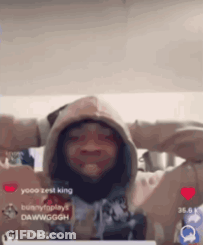 A Person Wearing A Hoodie With Their Hands Behind Their Head Is Making A Funny Face . GIF