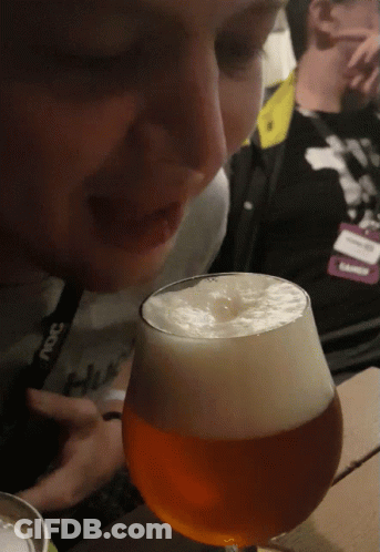 A Person Wearing A Lanyard That Says ' Snc ' On It Looks At A Glass Of Beer GIF