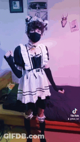 A Person Wearing A Maid Costume And A Mask Is Standing In A Room . GIF