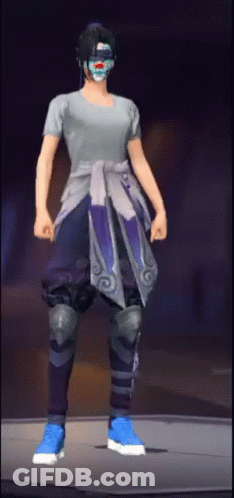 A Person Wearing A Mask And A Gray Shirt Is Standing On A Stage . GIF