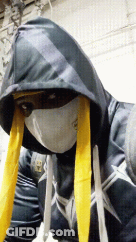 A Person Wearing A Mask And A Hoodie Has A Sticker On Their Shirt That Says ' Spiderman ' GIF
