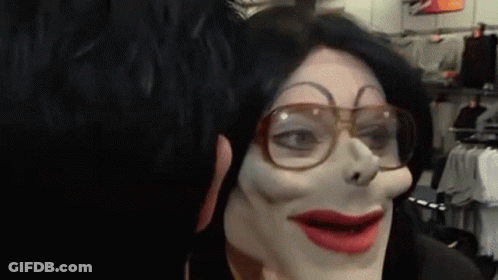 A Person Wearing A Mask And Glasses Looks At Another Person 'S Face GIF