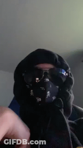 A Person Wearing A Mask And Sunglasses With Skulls On It GIF