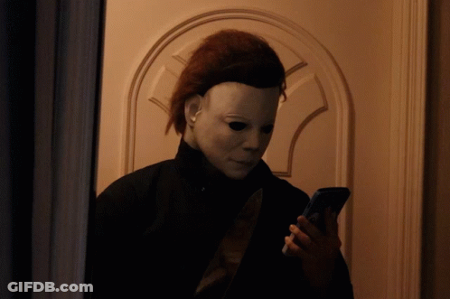 A Person Wearing A Mask Is Looking At Their Phone GIF