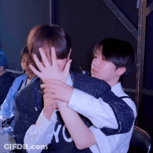 A Person Wearing A Nyc Shirt Covering Another Person 'S Face With Their Hands GIF