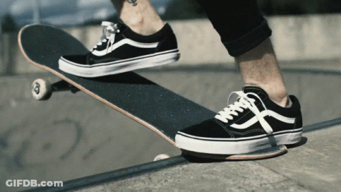 A Person Wearing A Pair Of Black And White Vans Shoes Rides A Skateboard GIF