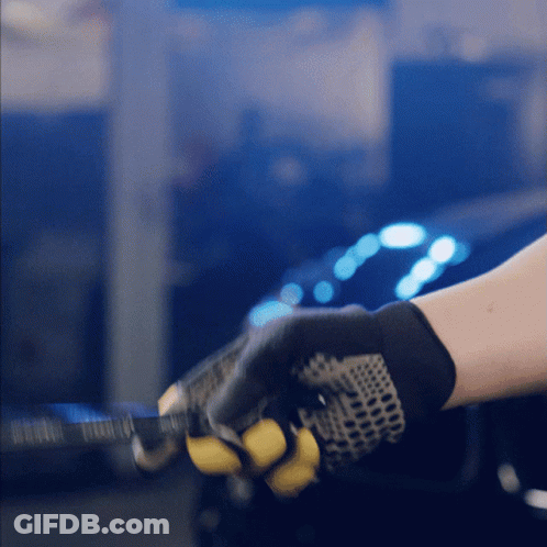 A Person Wearing A Pair Of Black And Yellow Gloves Is Holding A Yellow Object GIF