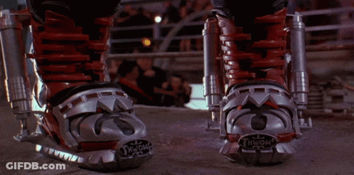 A Person Wearing A Pair Of Red And Silver Boots With The Letter N On The Bottom GIF