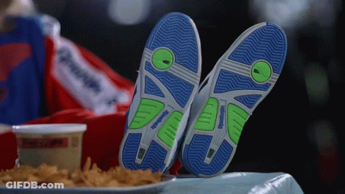 A Person Wearing A Pair Of Reebok Shoes Laying On A Table GIF