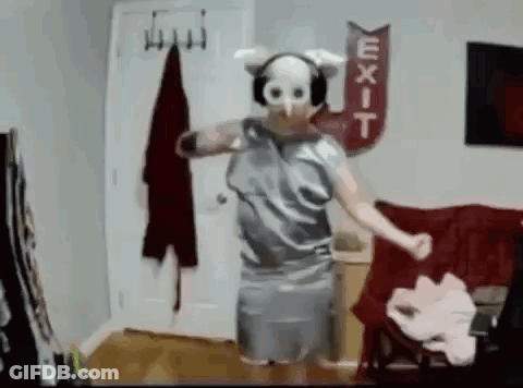 A Person Wearing A Pig Mask And Headphones Is Dancing In A Living Room . GIF