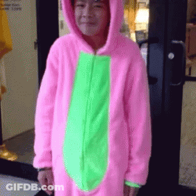 A Person Wearing A Pink And Green Costume Is Standing In Front Of A Door GIF