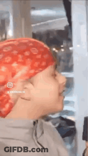 A Person Wearing A Red Bandana On Their Head Is Standing In A Room . GIF