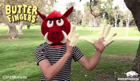 A Person Wearing A Red Boar Mask With Butter Fingers Written On The Top GIF