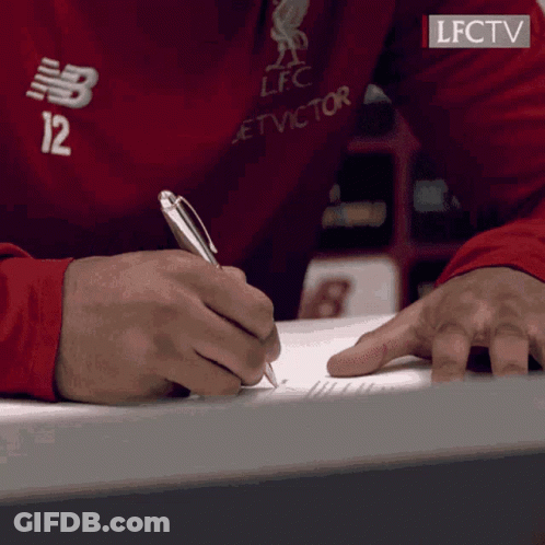 A Person Wearing A Red Shirt With The Number 12 On It Is Writing On A Piece Of Paper GIF