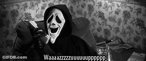 A Person Wearing A Scream Mask Is Talking On A Cell Phone While Sitting On A Couch . GIF