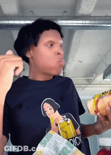A Person Wearing A Shirt That Says Dick Is Eating A Sandwich GIF