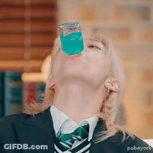 A Person Wearing A Suit And Tie Is Drinking From A Glass GIF