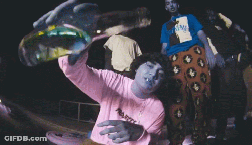 A Person Wearing A Supreme Shirt Is Holding A Bottle GIF