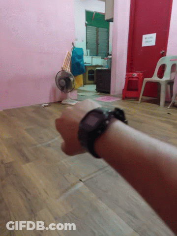 A Person Wearing A Watch Stands In A Room With A Sign On The Door That Says ' No Smoking ' GIF