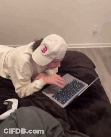 A Person Wearing A White Hat With The Letter B On It Is Using A Laptop GIF